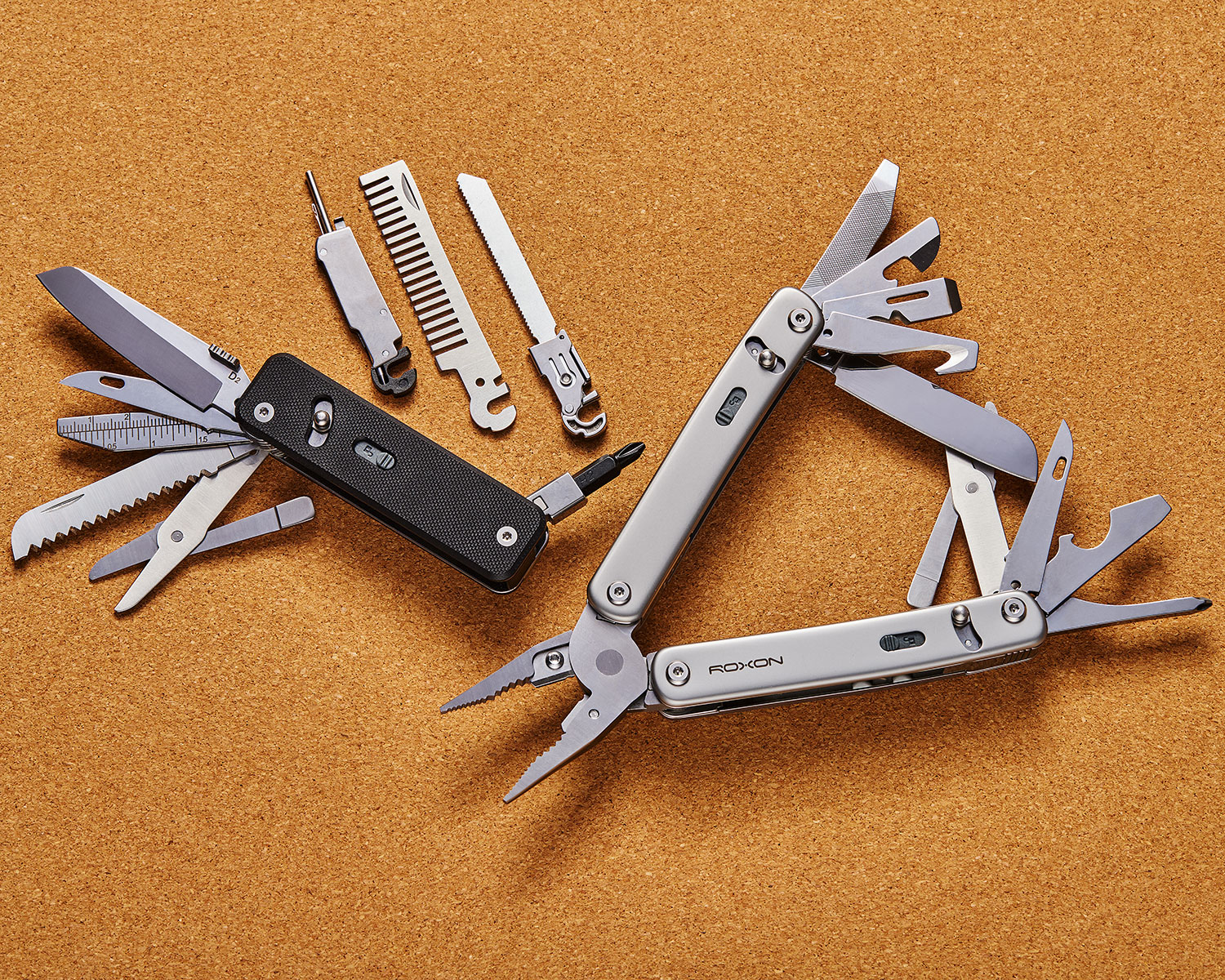 Two Roxon multitools with all tools fanning out of the handles, surrounded by replacement tools sold separately